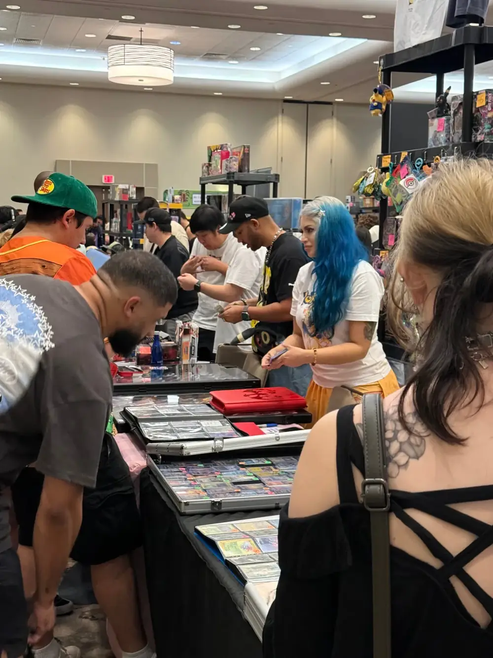 Collectors crowded around dealer tables trading Pokémon and One Piece singles at The Cactus TCG Show card show in Arizona