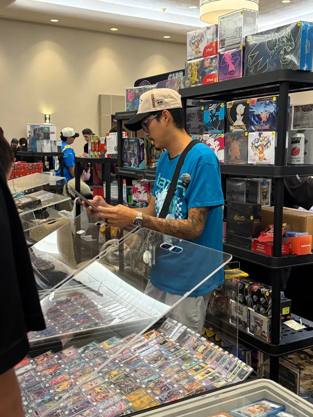 Shelves of sealed Pokémon Elite Trainer Boxes and booster boxes for sale at The Cactus TCG Show in Mesa, Arizona