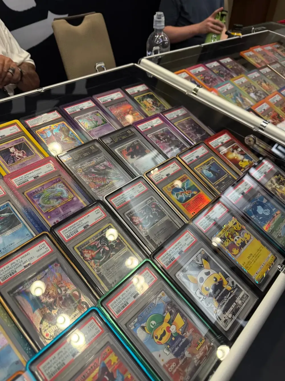 Display case packed with PSA graded vintage Charizard, Pikachu and Mew Pokémon slabs at The Cactus TCG Show in Mesa, Arizona