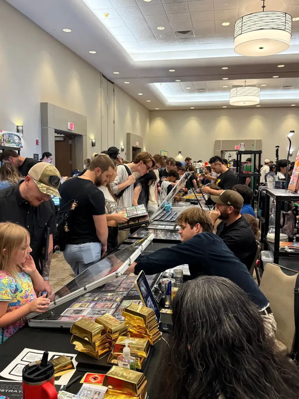 Busy Arizona Ballroom aisle of dealer tables and collectors at The Cactus TCG Show card show in Mesa, Arizona